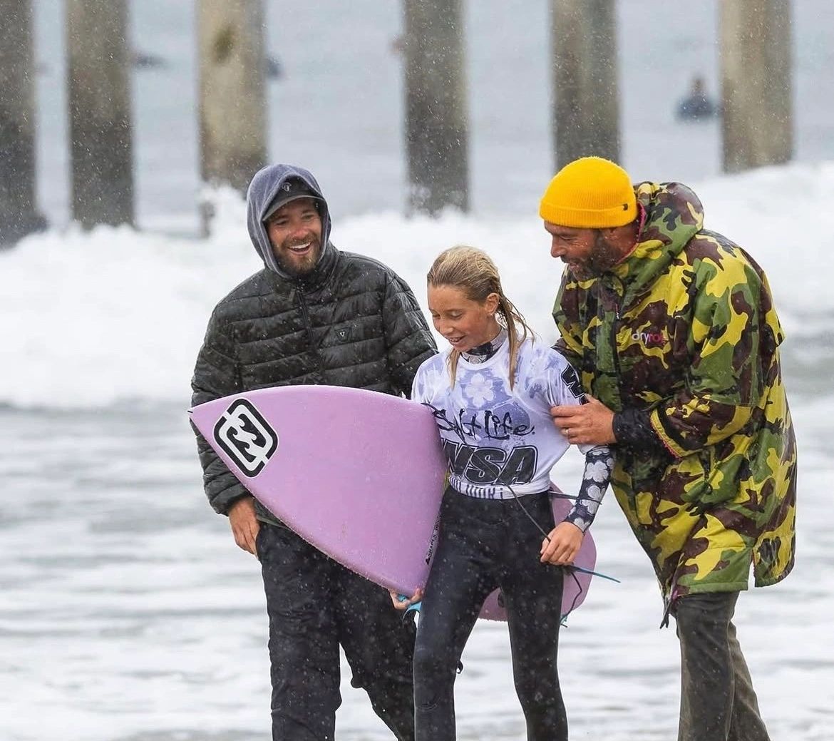 Surfer with coaches after a heat
